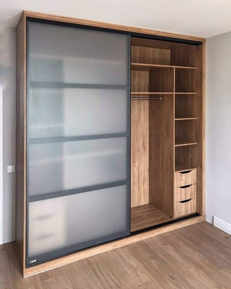 Portes coulissantes de dressing en verre dépoli et montants sombres.