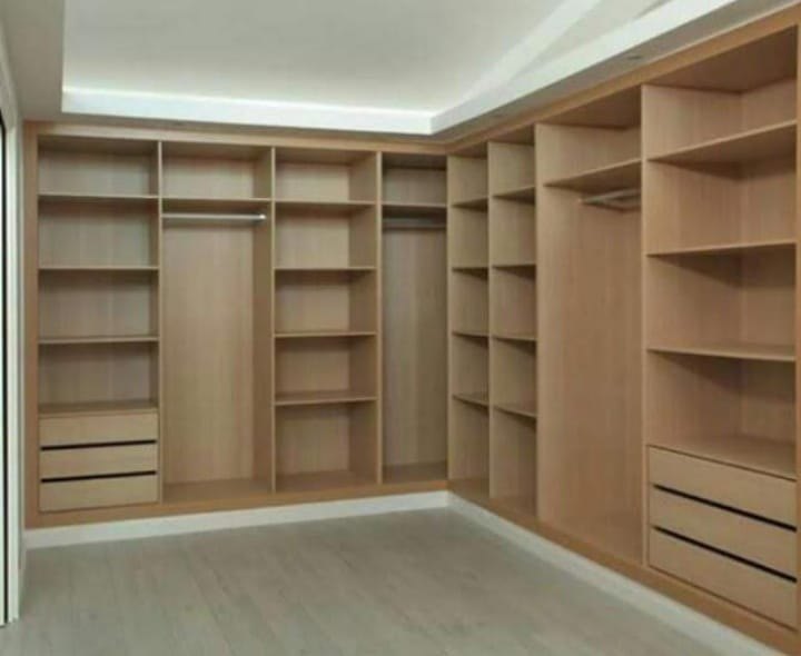 Dressing bois clair avec penderies et éclairage intérieur.