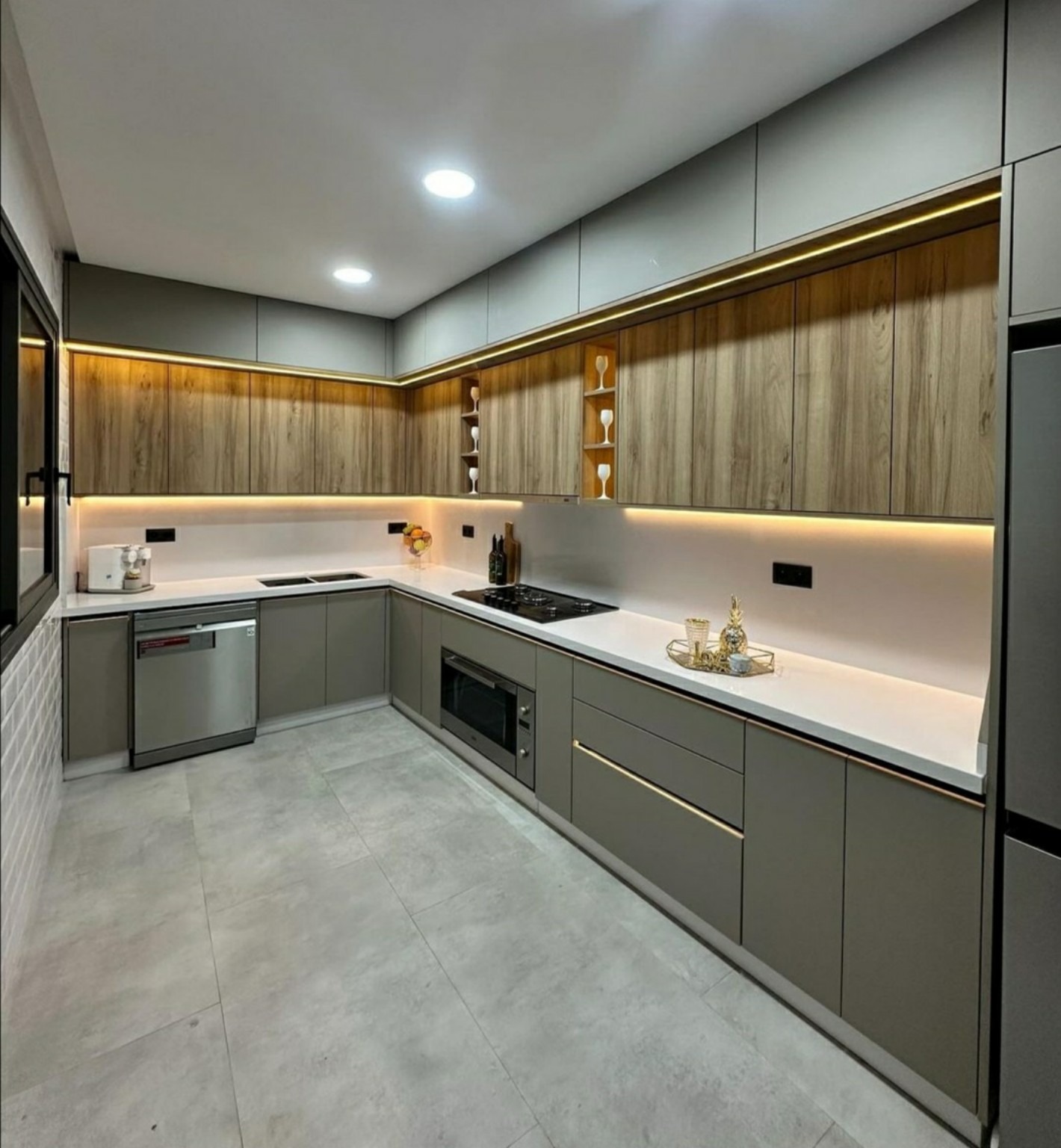 Cuisine grise et bois, plan clair et éclairage sous les meubles hauts.