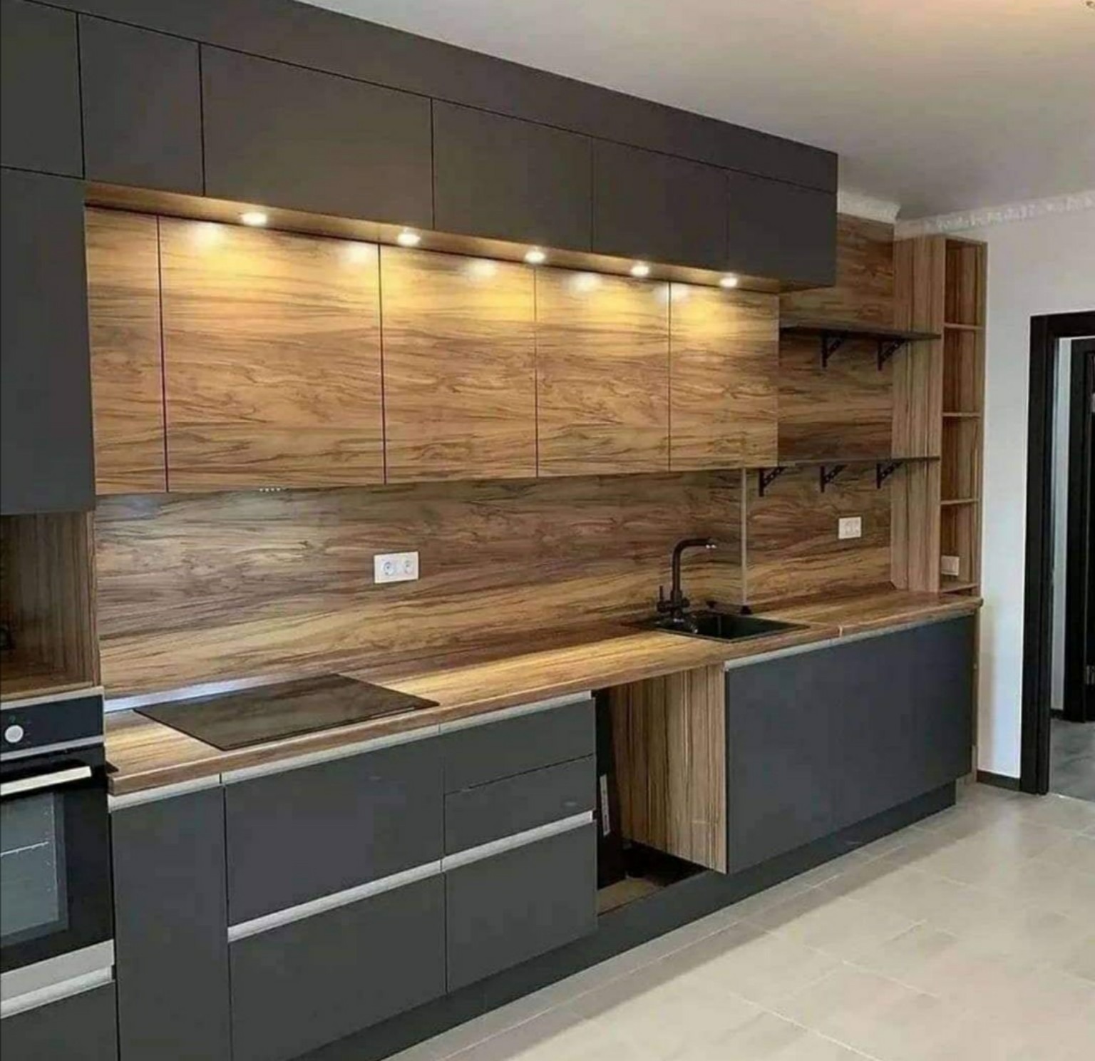 Façades anthracite et bois, crédence veinée et plan de travail clair.